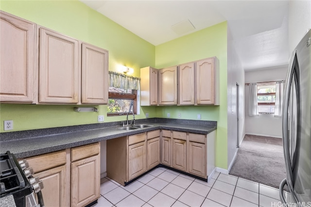 kitchen featuring light brown cabinetry, sink, light colored carpet, and stainless steel appliances