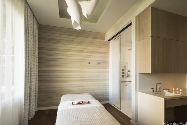 bathroom with wood walls, wood-type flooring, and sink