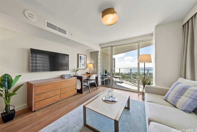 living room featuring a wall of windows and hardwood / wood-style flooring