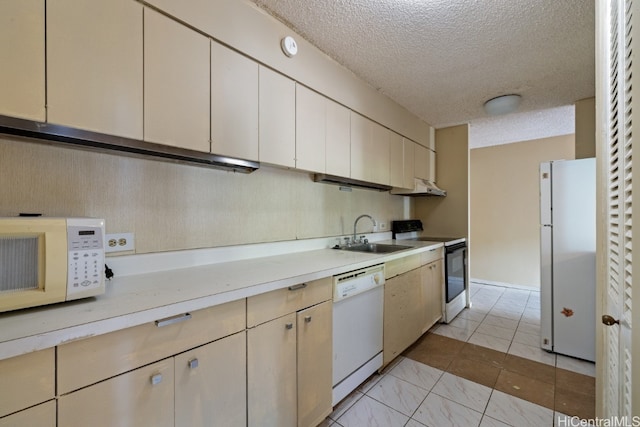 kitchen featuring white appliances, a textured ceiling, and sink