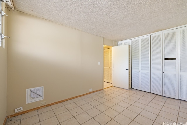 unfurnished bedroom featuring a textured ceiling and light tile patterned flooring