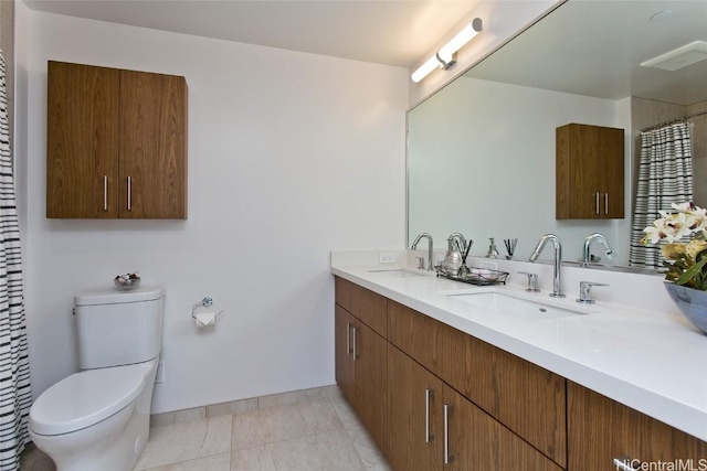 bathroom with tile patterned flooring, vanity, and toilet