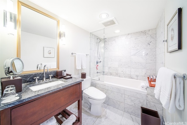 full bathroom featuring vanity, tiled shower / bath, and toilet