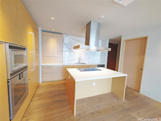 kitchen with a center island, stainless steel appliances, light hardwood / wood-style flooring, and island range hood