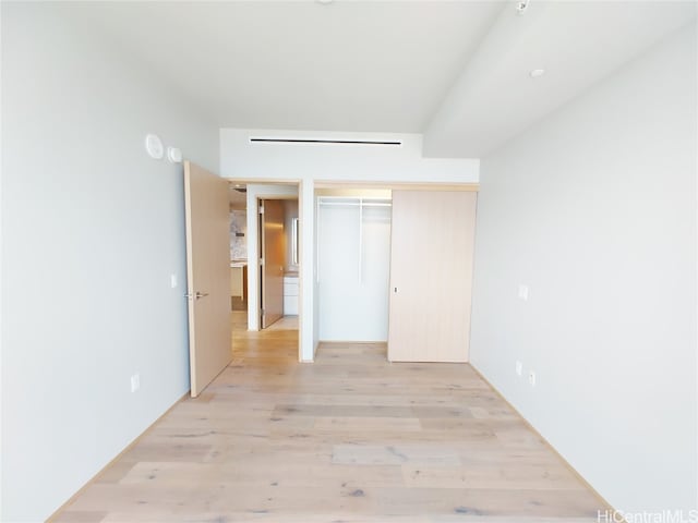 unfurnished bedroom featuring light hardwood / wood-style flooring and a closet