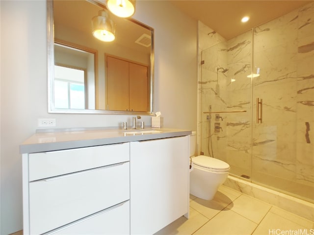 bathroom with vanity, toilet, tile patterned floors, and a shower with door