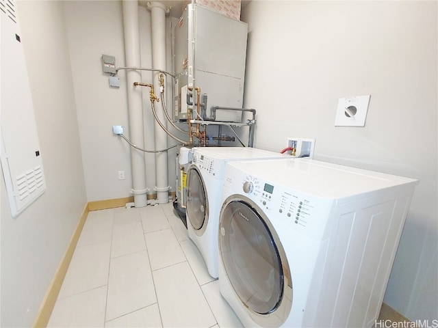 laundry area with independent washer and dryer and light tile patterned floors