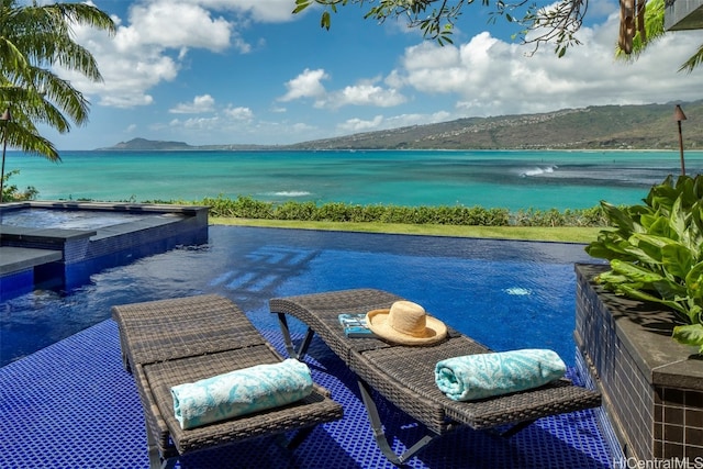 view of swimming pool featuring a water and mountain view