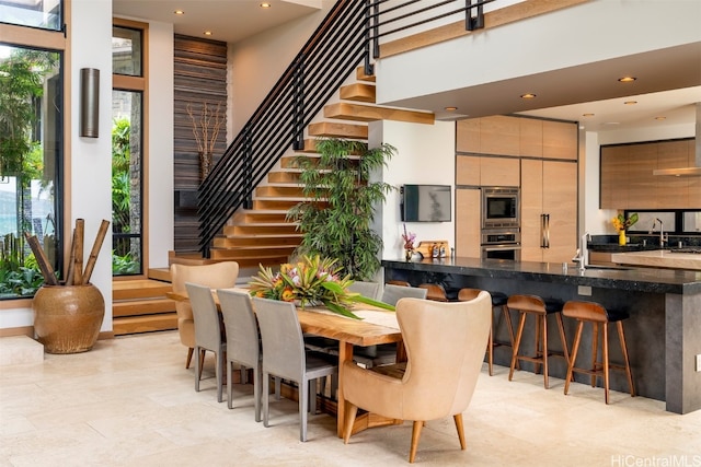 dining room with a healthy amount of sunlight and a high ceiling