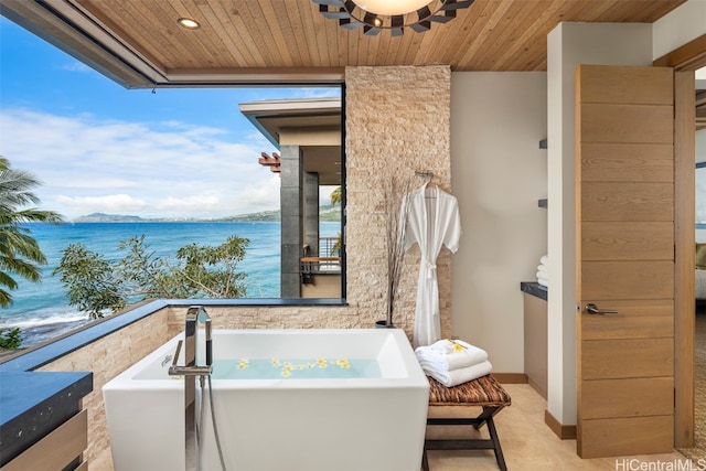 bathroom with wood ceiling, a water view, and a tub to relax in