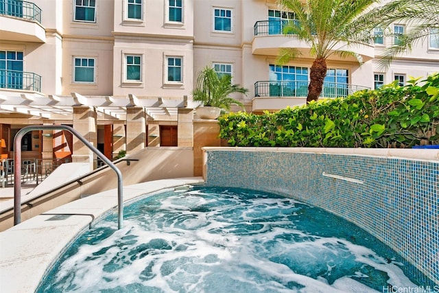 view of swimming pool with a jacuzzi and a pergola