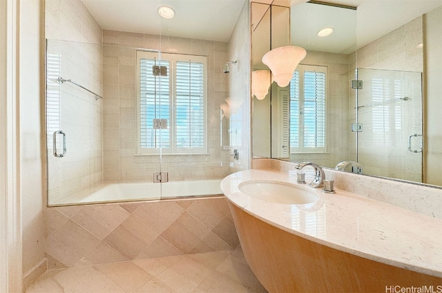 bathroom featuring sink and combined bath / shower with glass door