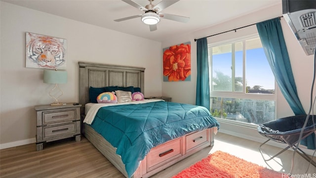 bedroom featuring ceiling fan, hardwood / wood-style flooring, and multiple windows