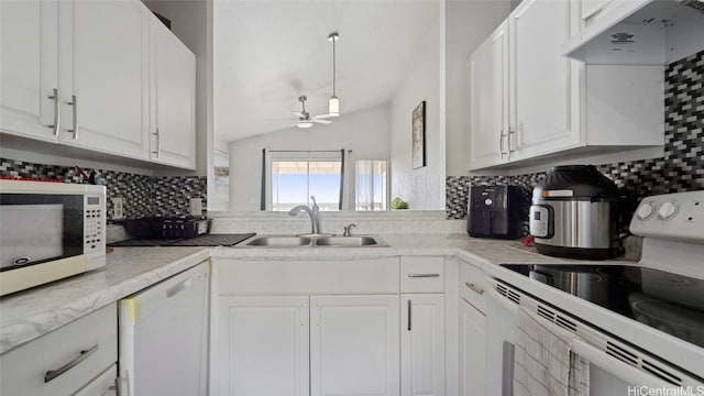 kitchen featuring lofted ceiling, sink, white cabinetry, white appliances, and tasteful backsplash