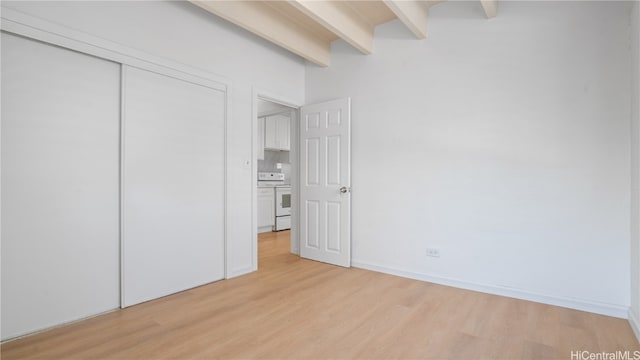 unfurnished bedroom with a closet, light hardwood / wood-style floors, and beamed ceiling