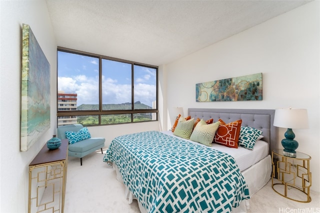 carpeted bedroom featuring a wall of windows and a textured ceiling