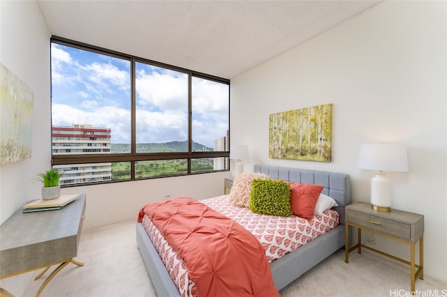 bedroom featuring a mountain view, carpet flooring, and multiple windows