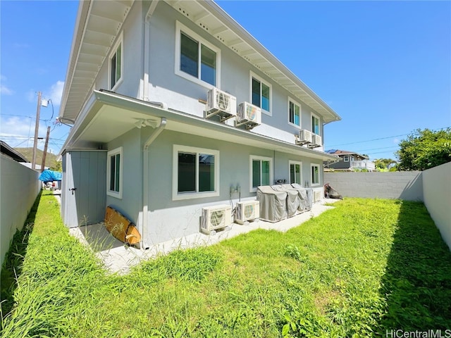 back of property featuring ac unit and a yard