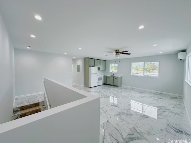 interior space with ceiling fan, sink, and a wall mounted air conditioner