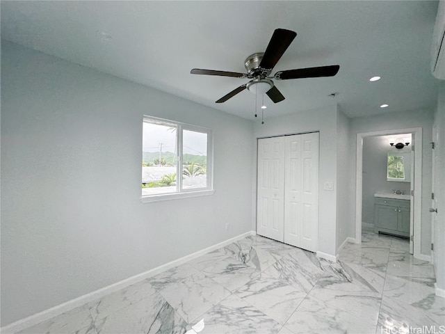 unfurnished bedroom featuring a closet, ensuite bathroom, and ceiling fan