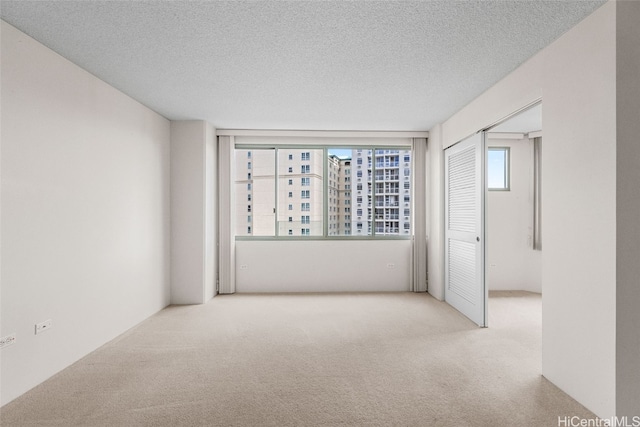 carpeted empty room with a textured ceiling