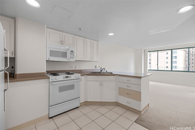 kitchen with white appliances, sink, kitchen peninsula, white cabinetry, and light tile patterned floors