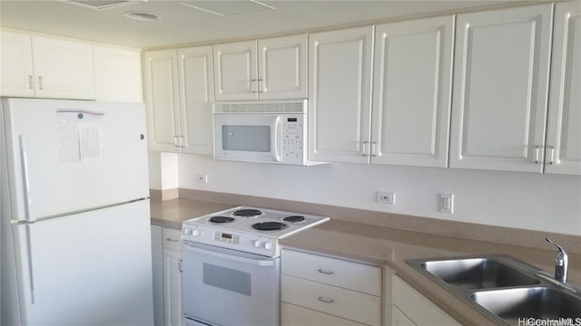 kitchen with sink, white cabinets, and white appliances