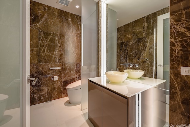 bathroom featuring vanity, toilet, and tile walls