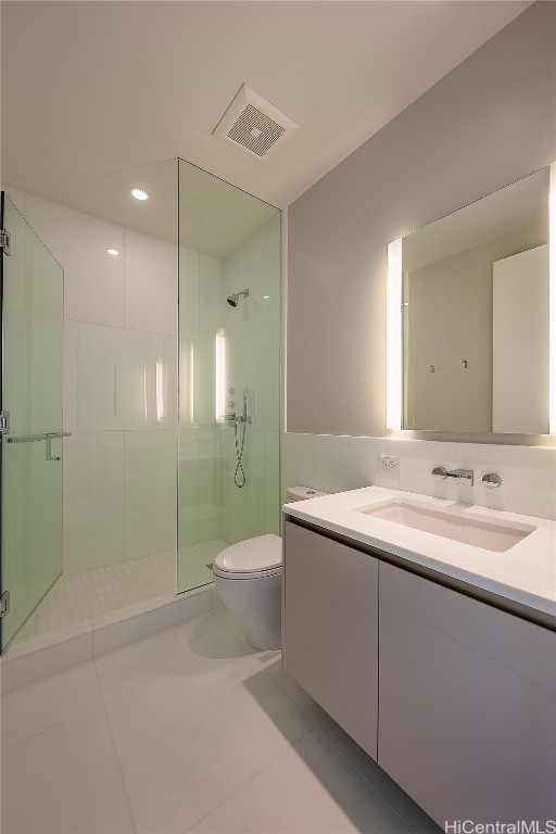 bathroom with vanity, toilet, tile patterned flooring, and a shower with door