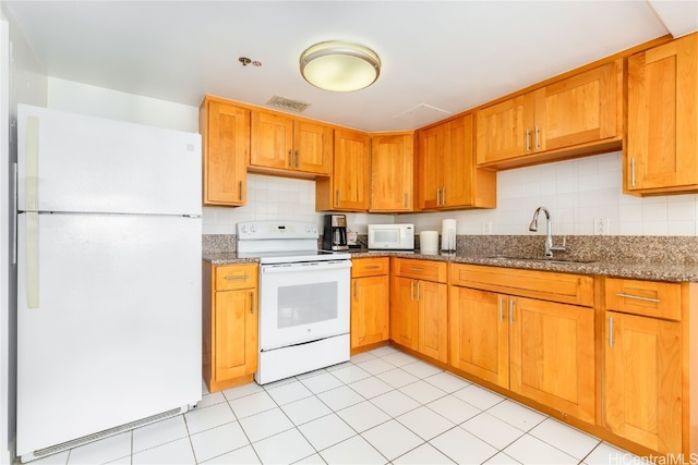 kitchen with decorative backsplash, sink, light tile patterned floors, light stone counters, and white appliances