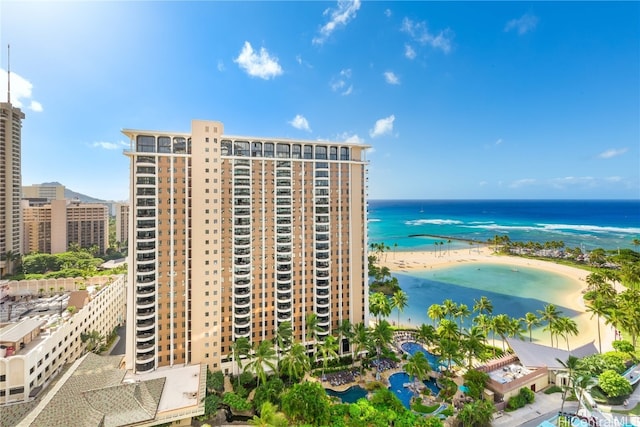 view of building exterior featuring a water view and a view of the beach