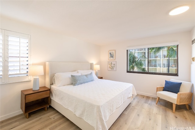 bedroom featuring multiple windows and light wood-type flooring