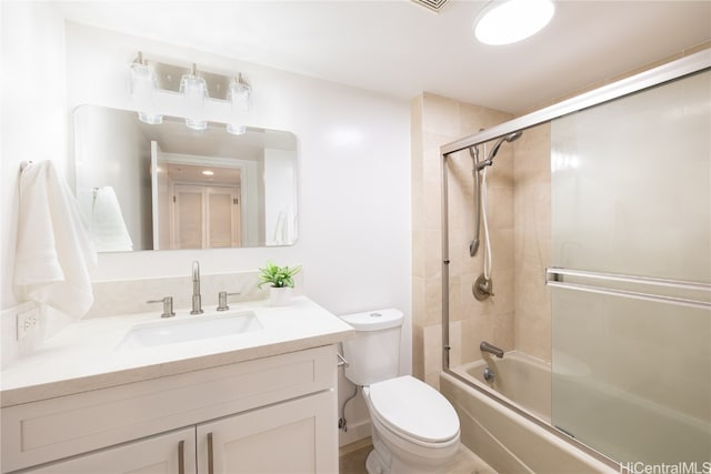 full bathroom featuring vanity, enclosed tub / shower combo, and toilet