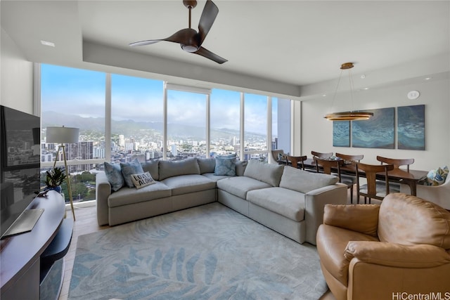 living room with ceiling fan and light hardwood / wood-style floors