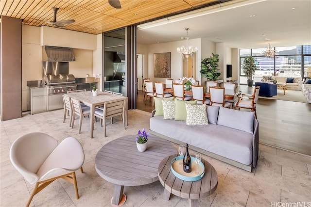 interior space featuring expansive windows, wooden ceiling, and ceiling fan with notable chandelier