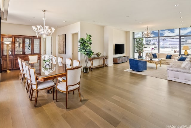 dining space with a wall of windows, a chandelier, and wood-type flooring