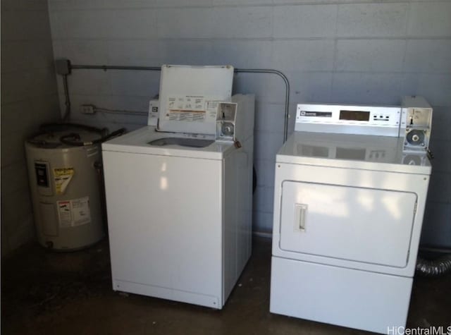 washroom with water heater and washing machine and dryer