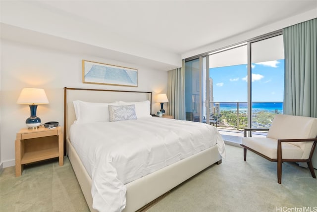 bedroom with expansive windows, access to outside, carpet flooring, and a water view