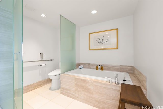 bathroom with tiled bath, toilet, and tile patterned floors