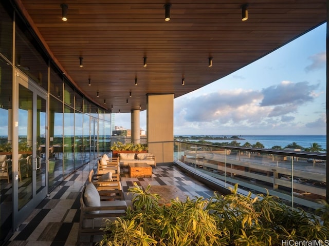 exterior space with a water view, a balcony, and an outdoor hangout area