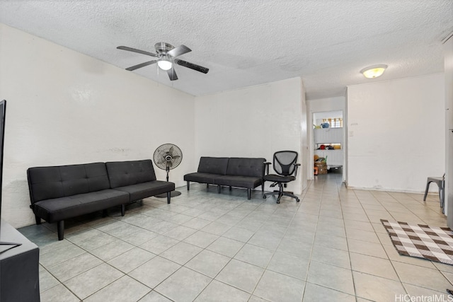 living room featuring ceiling fan, a textured ceiling, and light tile patterned floors