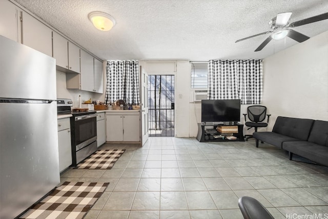 kitchen featuring appliances with stainless steel finishes, a textured ceiling, white cabinetry, and ceiling fan