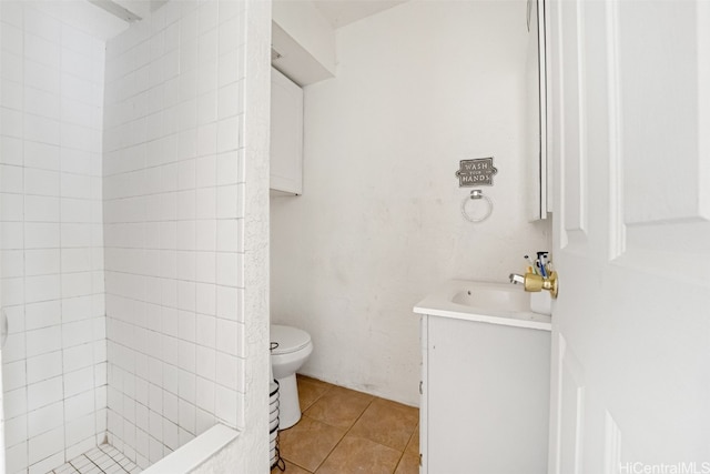 bathroom with vanity, toilet, tile patterned floors, and tiled shower