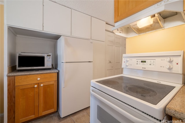 kitchen featuring white appliances, white cabinetry, and light tile patterned floors