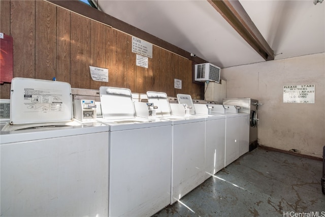 laundry area with washer and dryer and wooden walls