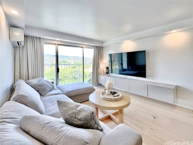 living room with light hardwood / wood-style flooring and a wall unit AC