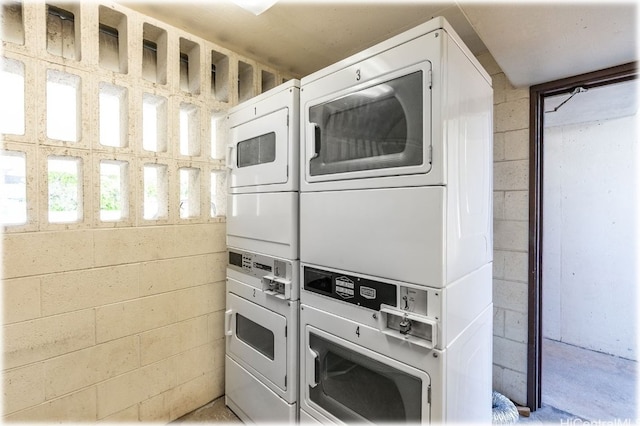 kitchen with oven, white cabinetry, and stacked washer and clothes dryer