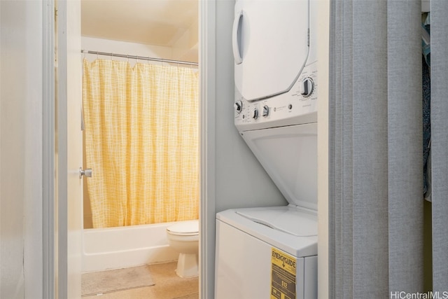 laundry room featuring light tile patterned floors and stacked washer / drying machine