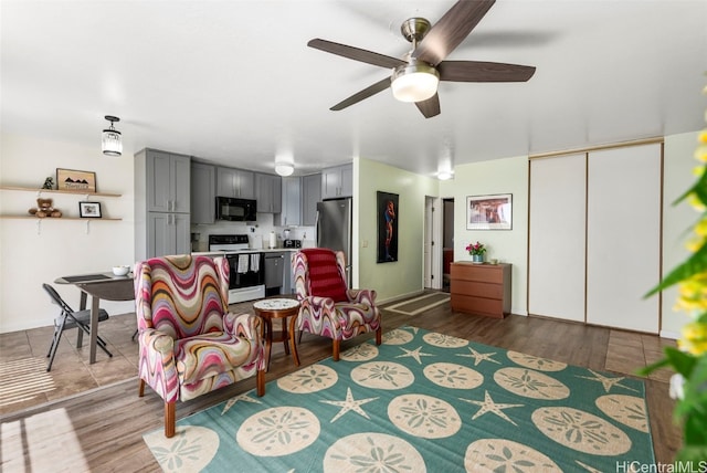 living room with ceiling fan and hardwood / wood-style flooring