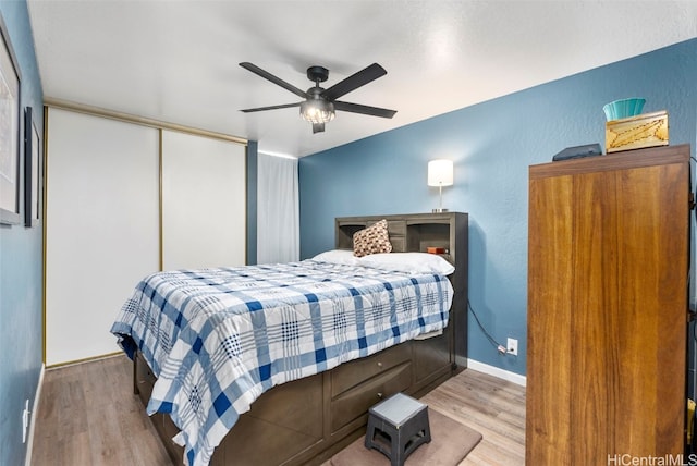 bedroom with light hardwood / wood-style flooring, a closet, and ceiling fan